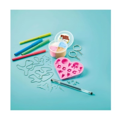 Kit para fazer bijutaria com forma de silicone cor-de-rosa em forma de coração, moldes de metal, tubos de cola e canetas coloridas sobre fundo azul claro.