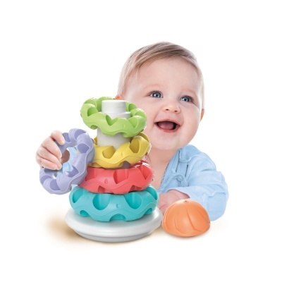 Bebé com brinquedo de argolas coloridas em fundo branco