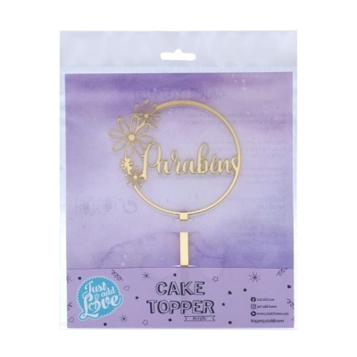 Topo de bolo dourado em acrílico com a palavra Parabéns e flores em embalagem transparente com fundo roxo