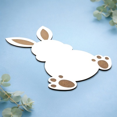 Recorte de coelho branco e castanho sobre fundo azul com folhas verdes