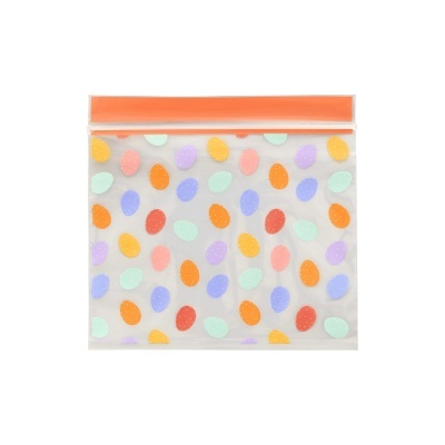 Saco plástico transparente com padrão de ovos coloridos e fecho laranja.