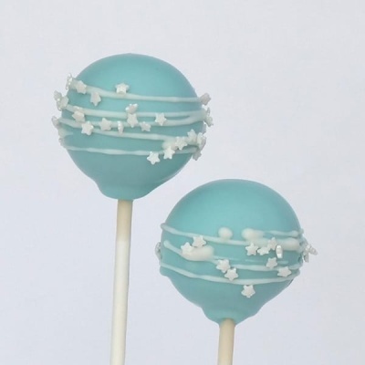 Dois cake pops azuis claros decorados com confeitos brancos em palitos