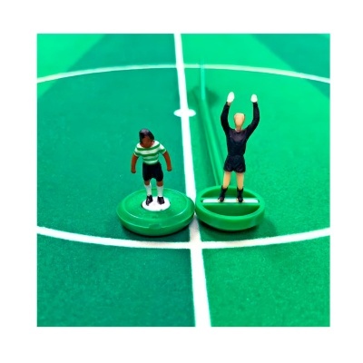 Miniaturas de jogadores de futebol de mesa numa mesa verde com linhas brancas