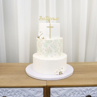 bolo branco decorado com flores e cruz dourada para batismo