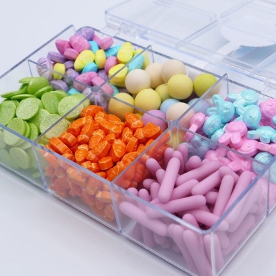 Caixa transparente com compartimentos de balas coloridas variadas