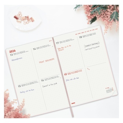 Agenda semanal aberta para 2026 com anotações e flores decorativas