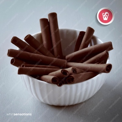 Tubo de chocolate castanho escuro num recipiente branco