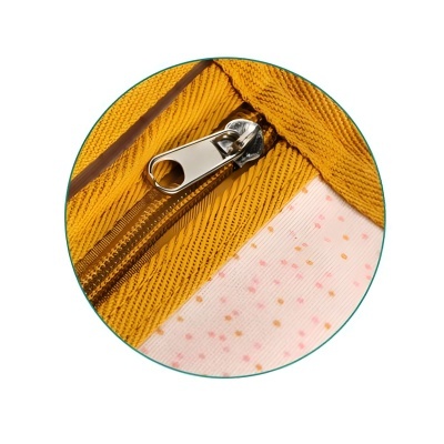 Fecho de correr metálico em tecido amarelo com padrão diagonal junto a tecido branco com pintas cor-de-rosa e laranja