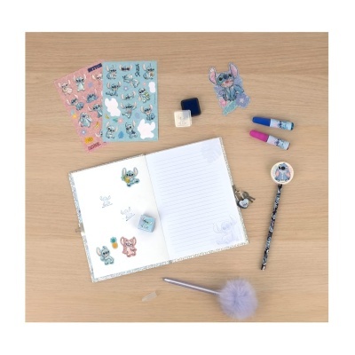 Material de escrita e papelaria com caderno, autocolantes Stitch, canetas, lápis, borracha, apontador e chaveiro sobre mesa de madeira