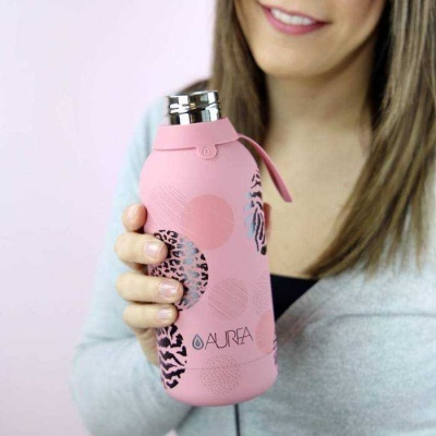 Garrafa térmica rosa com padrões coloridos segura por uma mulher