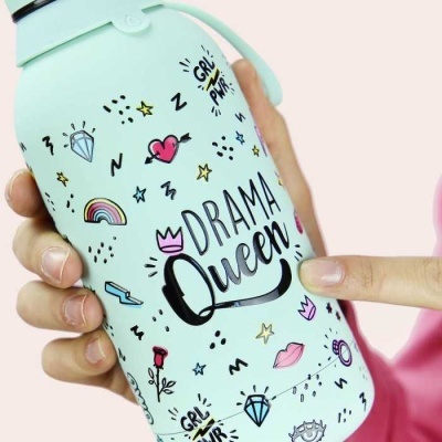Garrafa térmica verde com desenhos e texto 'DRAMA Queen', segurada por mão