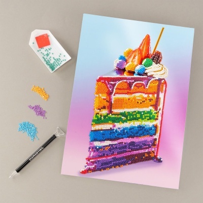 Quadro de diamantes de fatia de bolo colorida com frutas, cristais e ferramenta para aplicação.