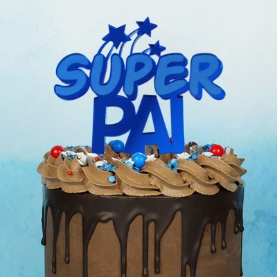 Bolo de chocolate decorado com cobertura a escorrer e topper azul com texto SUPER PAI