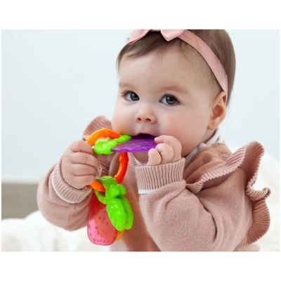 Bebé com brinquedo de dentição colorido e roupa rosa