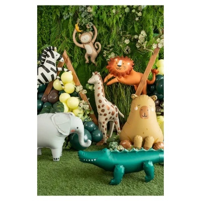 Balões insufláveis representando animais da selva, decorados com folhagem verde e balões amarelos, castanhos e verdes em fundo de relva artificial.
