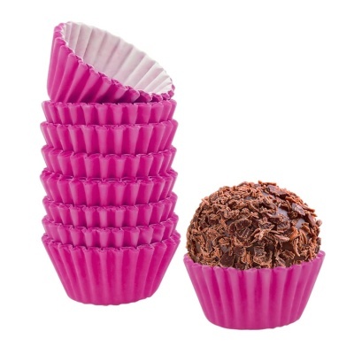 Forminhas cor-de-rosa para brigadeiros e brigadeiro com raspas de chocolate dentro de uma forminha