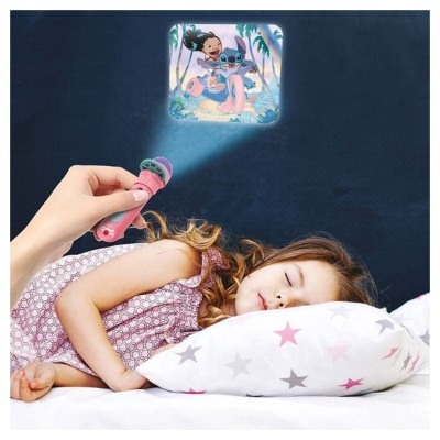 Criança dormindo com almofada de estrelas e projetor rosa a mostrar imagem animada na parede