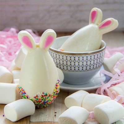 Chocolates em forma de coelho branco com detalhes rosa, marshmallows e chávena decorativa