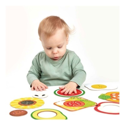 Bebé a jogar com peças de madeira coloridas de frutas e flores