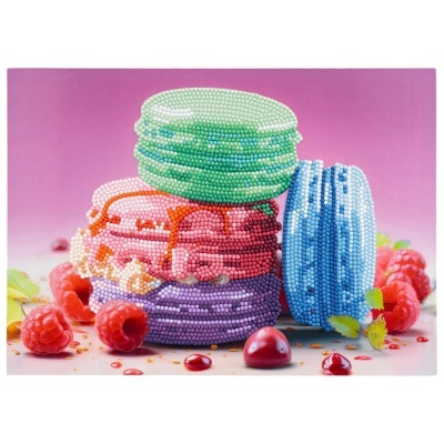 Macarons coloridos decorados com pérolas e frutas vermelhas em fundo rosa