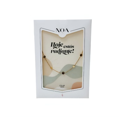 colar em aço dourado com pedras pretas em embalagem branca com texto e visor