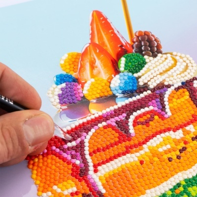 Aplicação de cristais coloridos em adesivo com desenho de frutas