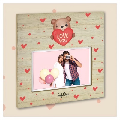 Moldura de madeira clara com corações vermelhos, ursinho com coração LOVE YOU e foto de casal com balões