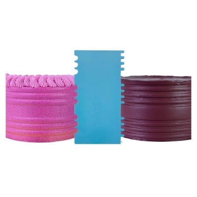 Raspador de bolos azul claro em plástico entre dois bolos decorados, um rosa e outro castanho