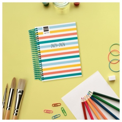 Agenda com capa colorida e material de desenho e papelaria sobre fundo amarelo