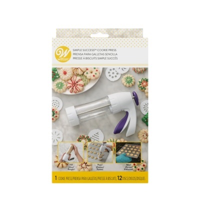 Prensa para galletas Wilton com discos decorativos e bolachas coloridas em embalagem.