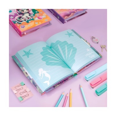 Diário infantil aberto com lápis, clips e chaveiro sobre mesa lilás