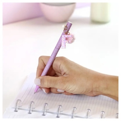 Caneta cor-de-rosa com pendente F e caderno de argolas quadriculado