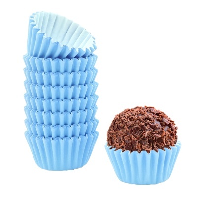 Formas de papel azul claro com um brigadeiro coberto de chocolate