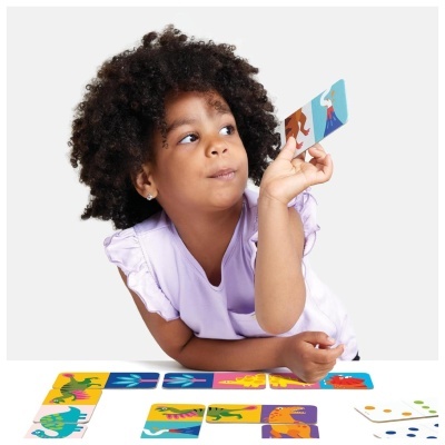 Criança a jogar com cartas coloridas de dinossauros e vulcão