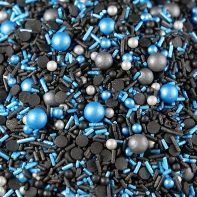 Confeites de açúcar coloridos azuis, prateados e pretos com várias formas e texturas.