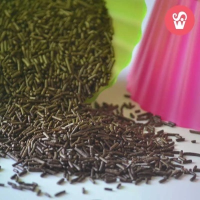 Grânulos de fertilizante orgânico castanho escuro com recipiente verde e molde rosa