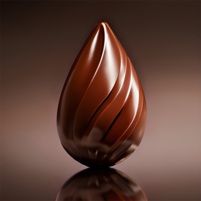 Doce de chocolate em forma de gota castanho-escuro com riscas decorativas sobre superfície refletora