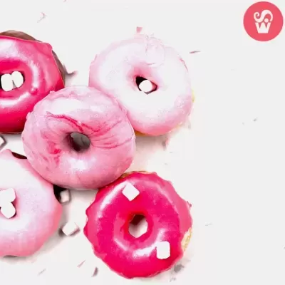 Donuts rosa e vermelhos com pequenos cubos brancos, sobre fundo branco
