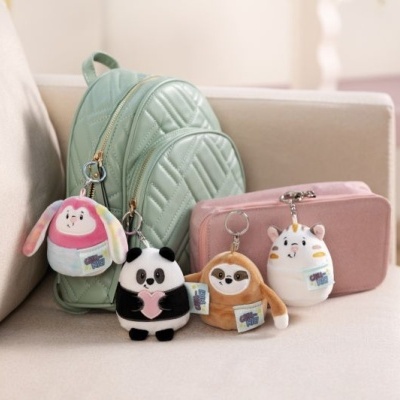 Mochila verde água com bolsas rosas e chaveiros de pelúcia animal