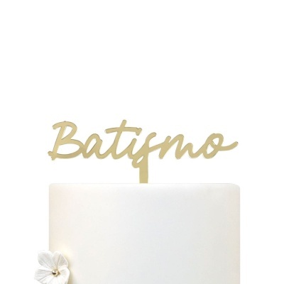 Topo de bolo dourado com texto Batismo e bolo branco com flor branca
