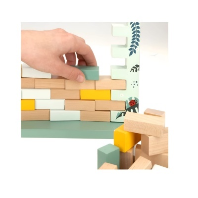 Blocos de madeira coloridos empilhados numa base verde com moldura decorada