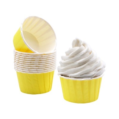 Forminhas amarelas para cupcake, empilhadas e uma com cobertura branca