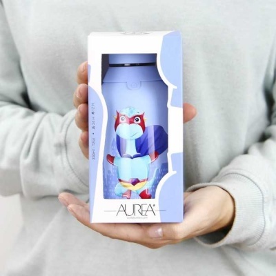 Figura colorida de papagaio em caixa branca com visor transparente, segurada por mãos de pessoa com casaco cinza