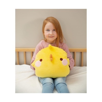 Peluche amarelo quadrado segurado por criança sentada numa cama.