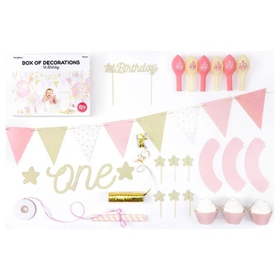 Conjunto de decoração para festa de primeira aniversário com balões, bandeirolas e toppers em tons rosa, branco e dourado.