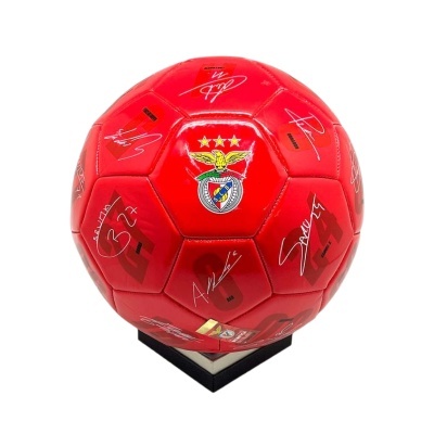 Bola de futebol vermelha do Benfica com assinaturas brancas em suporte preto