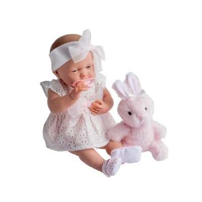 Boneca bebê com vestido branco e faixa, sentada ao lado de coelho de pelúcia rosa