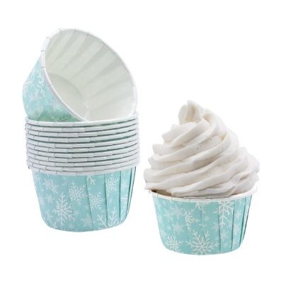 Forminhas azuis com flocos de neve e cupcake com creme branco.