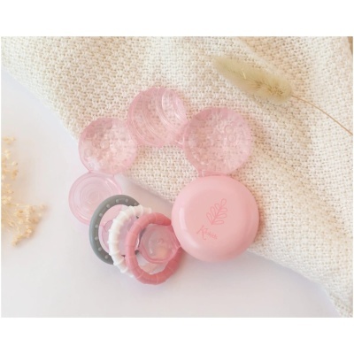 Brinquedo para bebé colorido com texturas sobre tecido bege