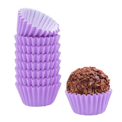 Copos de papel roxos para brigadeiro e um brigadeiro coberto com raspas de chocolate